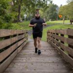 Christian Alexandersen running across the bridge at Little Buffalo State Park