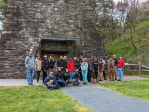 A group of Hispanic and Latino Professionals group stand in front of an old iron ore furnace at Pine Grove State Park