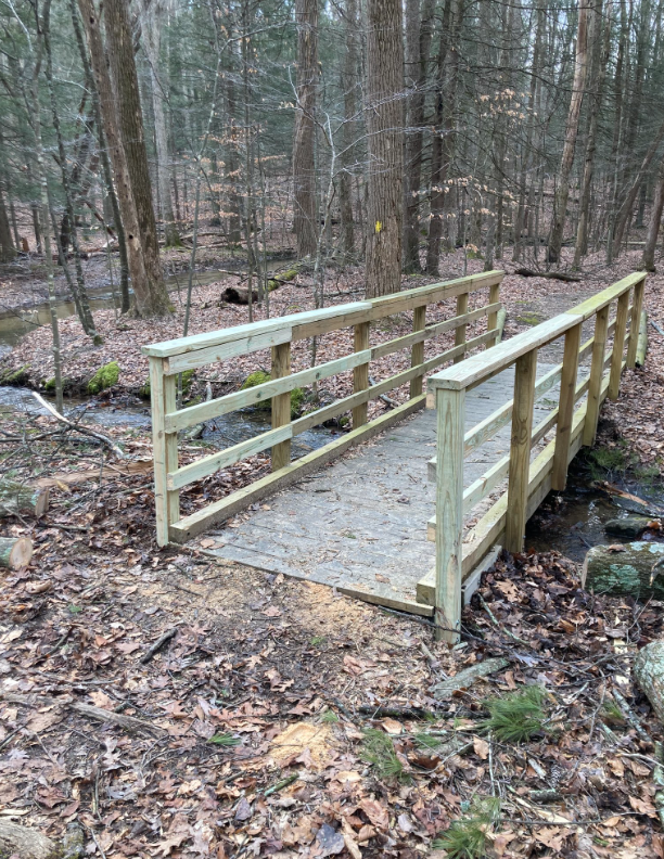 A repaired foot bridge with new section of handrails added